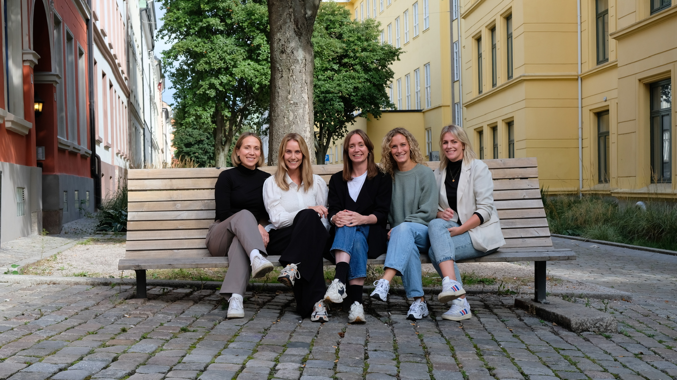 De fem logopedene i A-logopedene sitter samlet på en benk i en gate i Oslo.